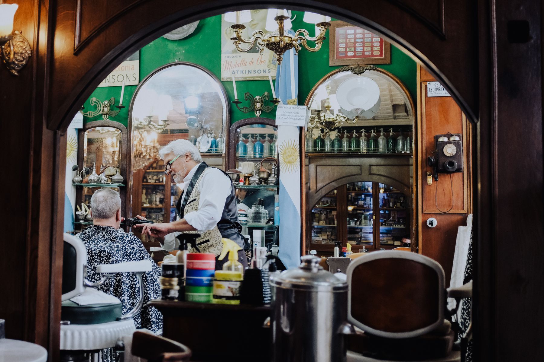 Barber working with a customer inside a vintage barbershop