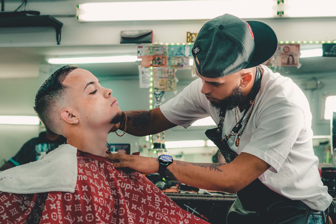 Barber carefully trimming a customer's beard